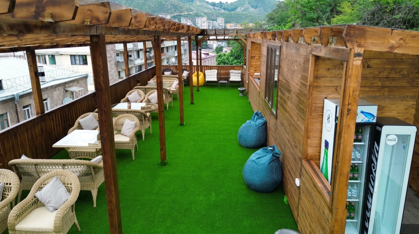 The open-air café at ThreeWays, with wicker seating, a wooden pergola and mountain views